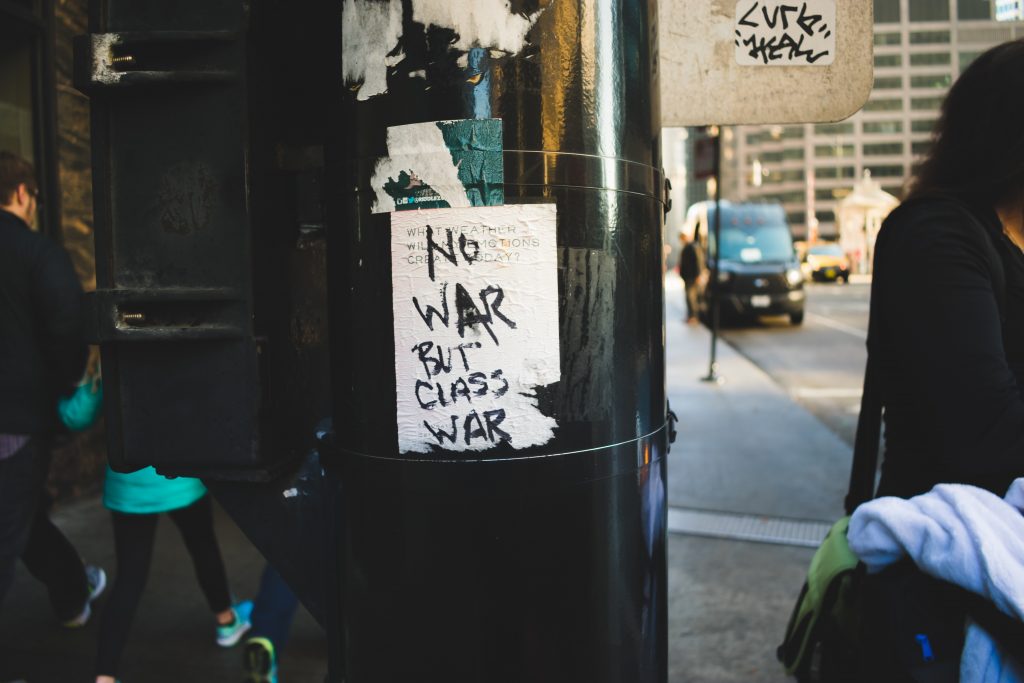 A poster on a pillar with the words "no war but class war" written in black